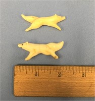 A pair of 1.75" white ivory sled dogs       (700)
