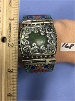 An ornate silver bracelet with turquoise, corral,