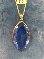 Large faceted blue stone approx. 2.5" on a gold co