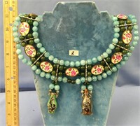 A silver and four strand beaded necklace with flor