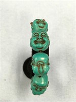 Turquoise colored Buddha heads made into a stretch