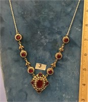 Costume jewelry necklace with ruby colored stones