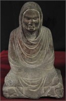 ASIAN CARVED STONE FIGURE OF A SEATED MONK.
