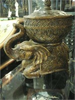 Bronze colored elephant with a bowl and lid