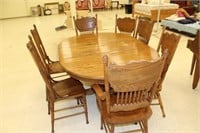 Oak dining table, 7 pressed back chairs, 2 leaves
