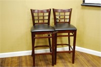 a pair of wooden bar stools, with cushioned