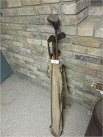 Antique wooden golf clubs in with the bag