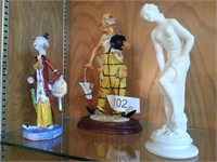 Two clown figures and nude female figure