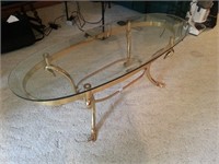 Glass oval top coffee table with sawn head base