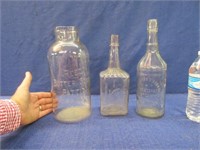 3 larger antique embossed clear bottles