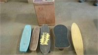 5 smaller skateboards and a wooden box