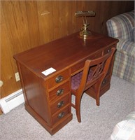 Mahogany kneehole desk with chair and brass lamp