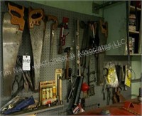Group of tools hanging on pegboard- saws,