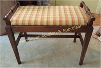 Wood vanity bench with plaid upholstery on seat
