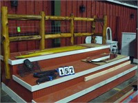 3 level riser platform with wooden fence backing.