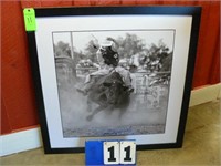 Framed black and white picture of bull rider.