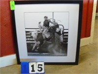 Framed black and white picture of bull rider.