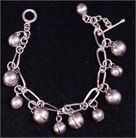 A silver chain link bracelet with round bells