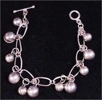 A silver chain link bracelet with round bells