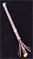 A silver retractable champagne whisk with
