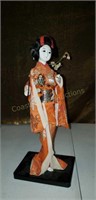 Vintage geisha girl doll on wood stand