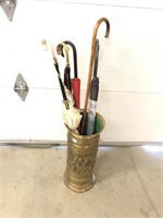 Brass umbrella stand with a ladies cane and two
