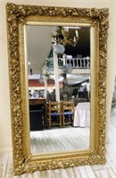 Floral and Foliate Gilt Framed Beveled Mirror.
