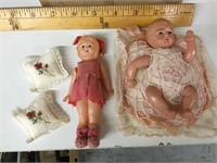 Pair of small Celluloid dolls with cushions.