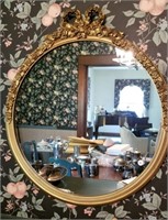 Round wall mirror, ornate décor on gold look frame