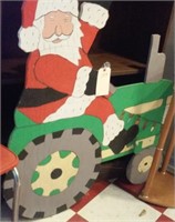 Santa driving big green tractor yard art