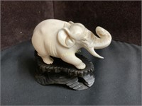 SMALL CARVED ELEPHANT ON TIMBER BASE