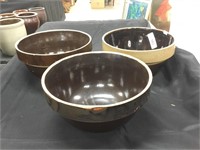 Three large pottery mixing bowls.