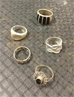 Five sterling silver rings.