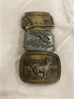 Three Remington belt buckles
