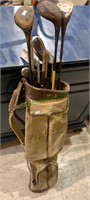 Antique golf bag with three old golf clubs and