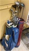 Two golf bags, a red and a blue with golf clubs,