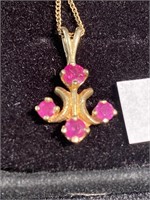 Pendant with ruby colored stones on a gold
