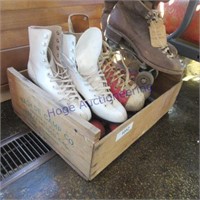 Wood box full of 2 roller skates and ice skates