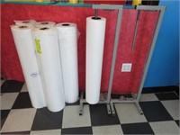 Two Table Covering Racks and Six Rolls of Paper