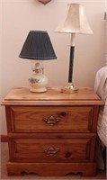 Oak 2 drawer nightstand with lamps and contents.