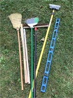 Assorted brooms and level