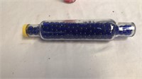 Glass rolling pin full of blue marbles