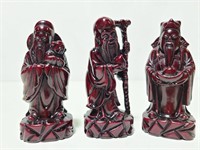 Trio of carved monk figurines