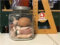 Coffee jar filled with doll parts