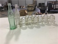 8 glass insulators and 2 pop bottles