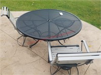 black round metal table and 2 patio chairs