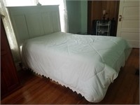 White wooden bed frame including linens
