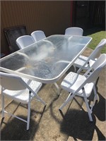 Glass Top Patio Table and 6 Folding Plastic Chairs