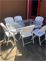 Glass Patio Table and 6 Folding Plastic Chairs