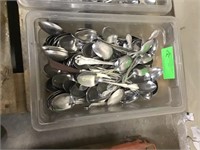 Bin of assorted spoons